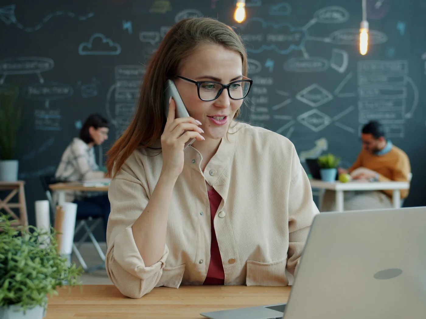 Een collega van i-Reserve aan de telefoon met een klant, met de laptop open