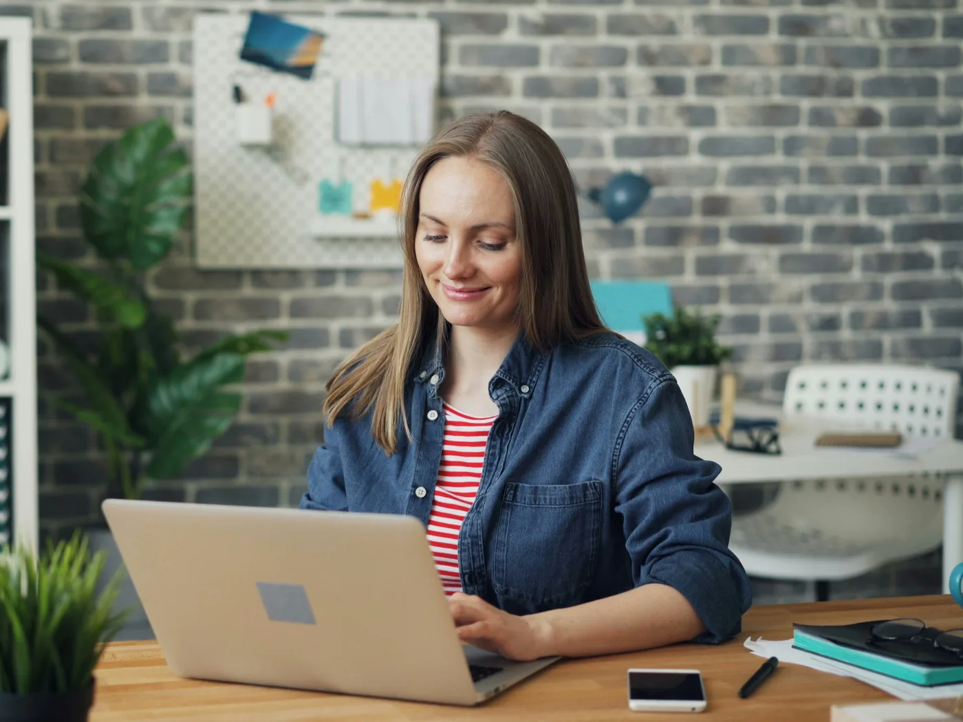 Een vrouw gaat glimlachend aan de slag op haar laptop