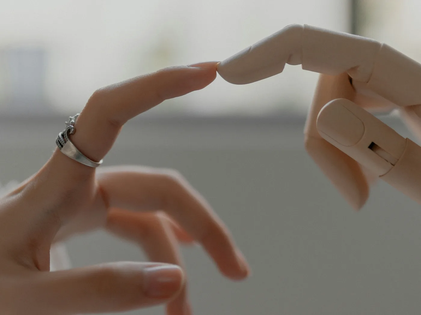 Een mensenhand en een houten robothand die elkaar bijna raken